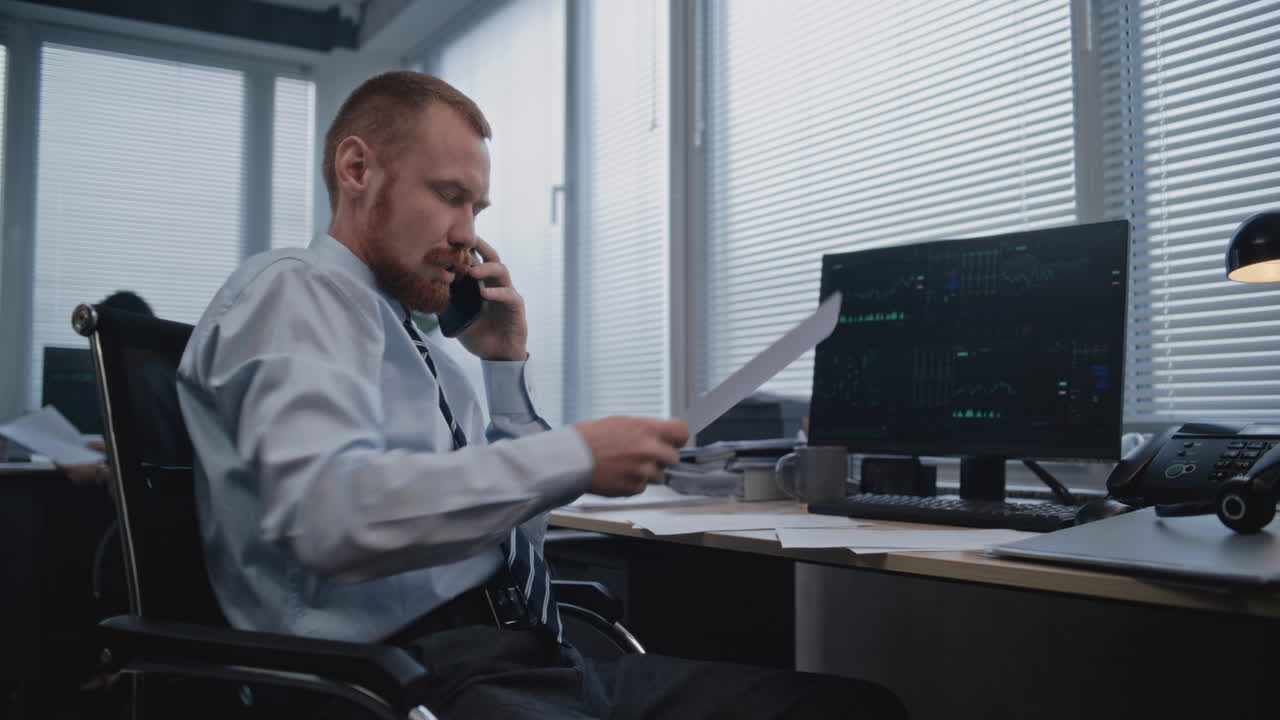 hombre de negocios en el teléfono revisando documentos en la oficina