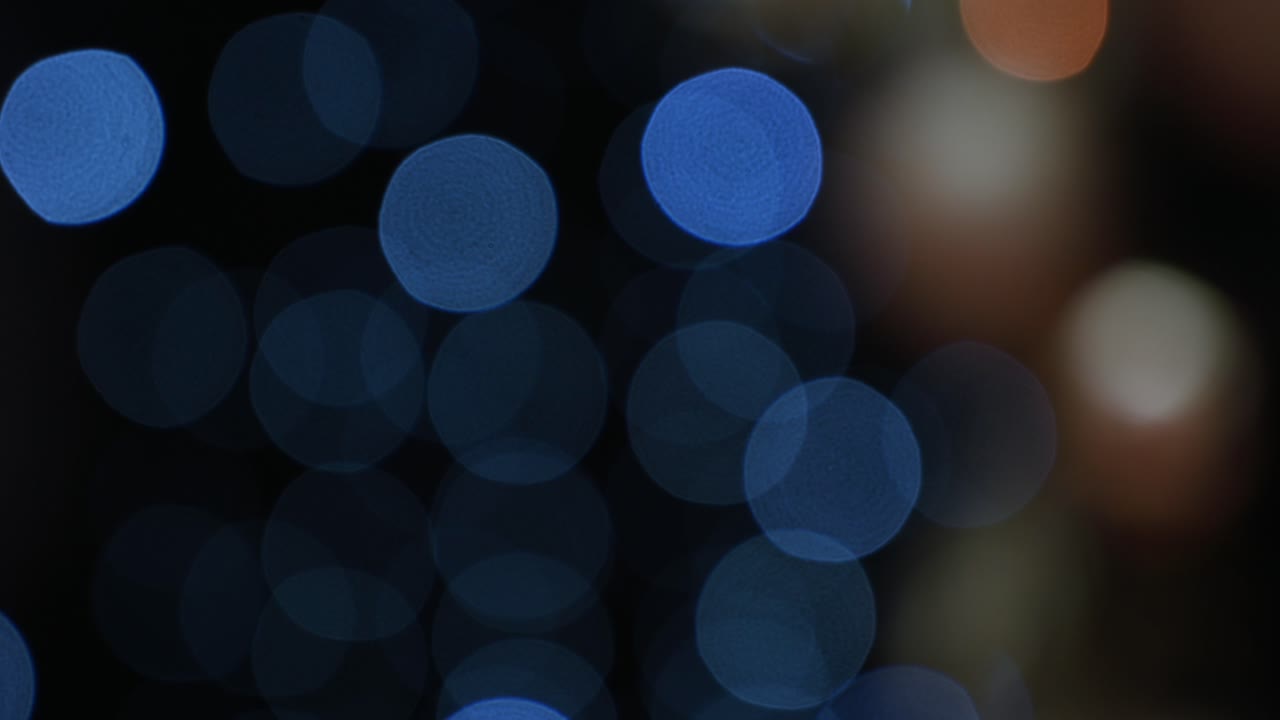 Blurred view of blue Christmas lights on a black background