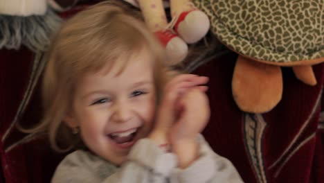 close up of a little blonde cute girl face. girl smiling. inside. portrait shot