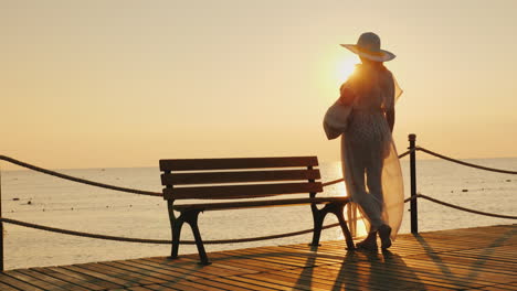 Una-Chica-Muy-Delgada-Con-Un-Pareo-En-Desarrollo-Y-Un-Elegante-Sombrero-De-Ala-Ancha-Está-De-Pie-En-El-Muelle.