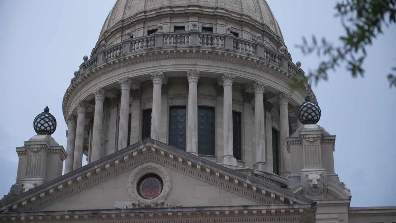 Rack focus in, close up columns: Stormy skies over the Mississippi State Capitol building. Jackson, MS.