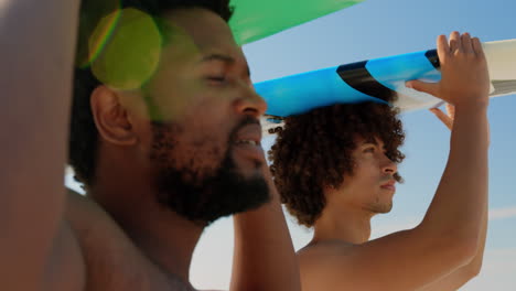 young friends carrying surfboard on head 4k