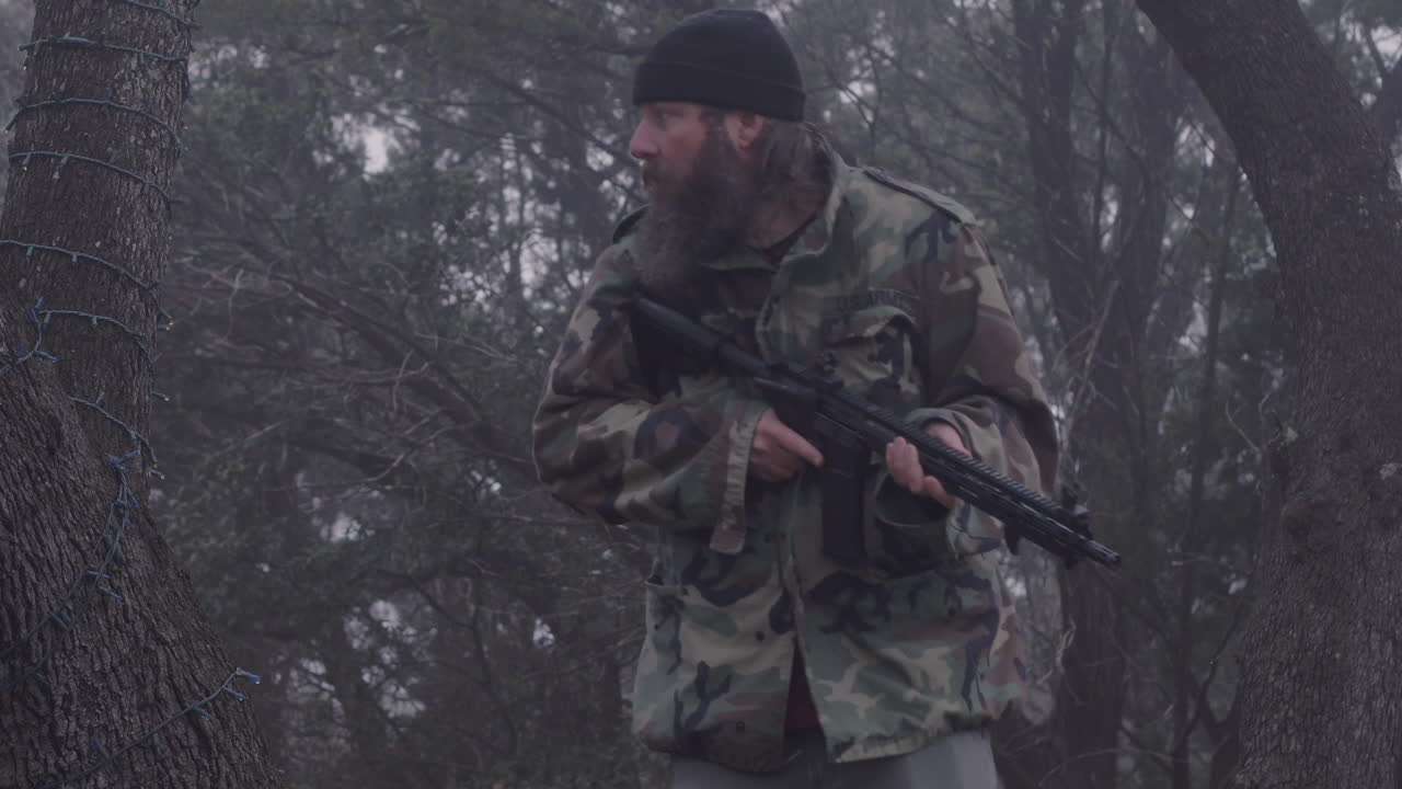 un cazador camuflado se mueve silenciosamente en el bosque frío y brumoso, armado con un arma, escuchando animales salvajes, 23