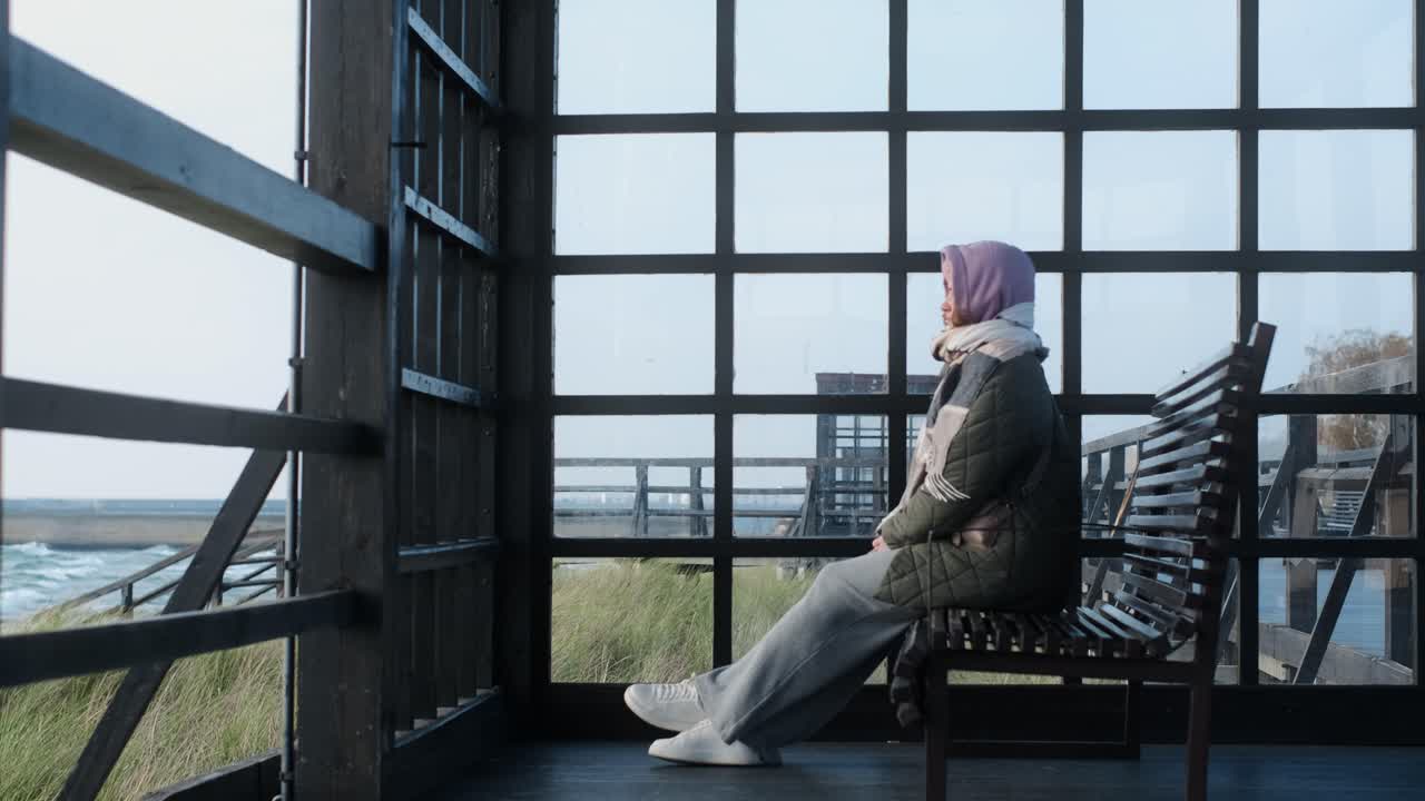 Woman Sitting in a Wooden Gazebo by the Beach