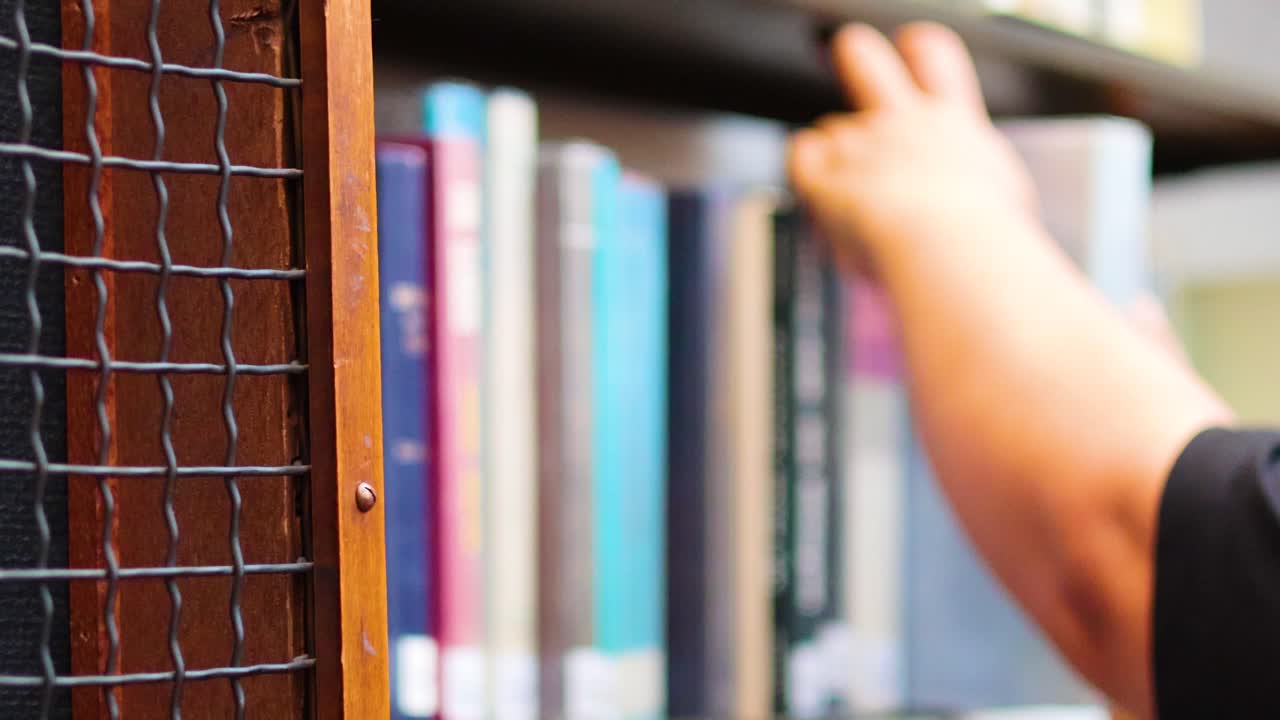 mano alcanzando un libro en el estante