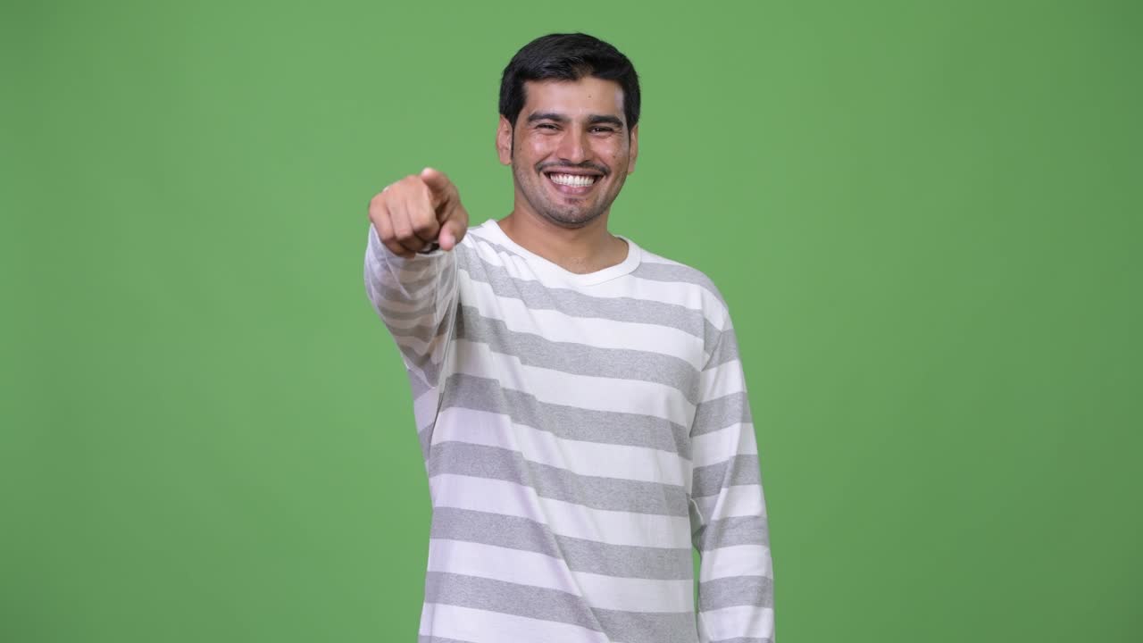 Young handsome Persian man pointing at camera