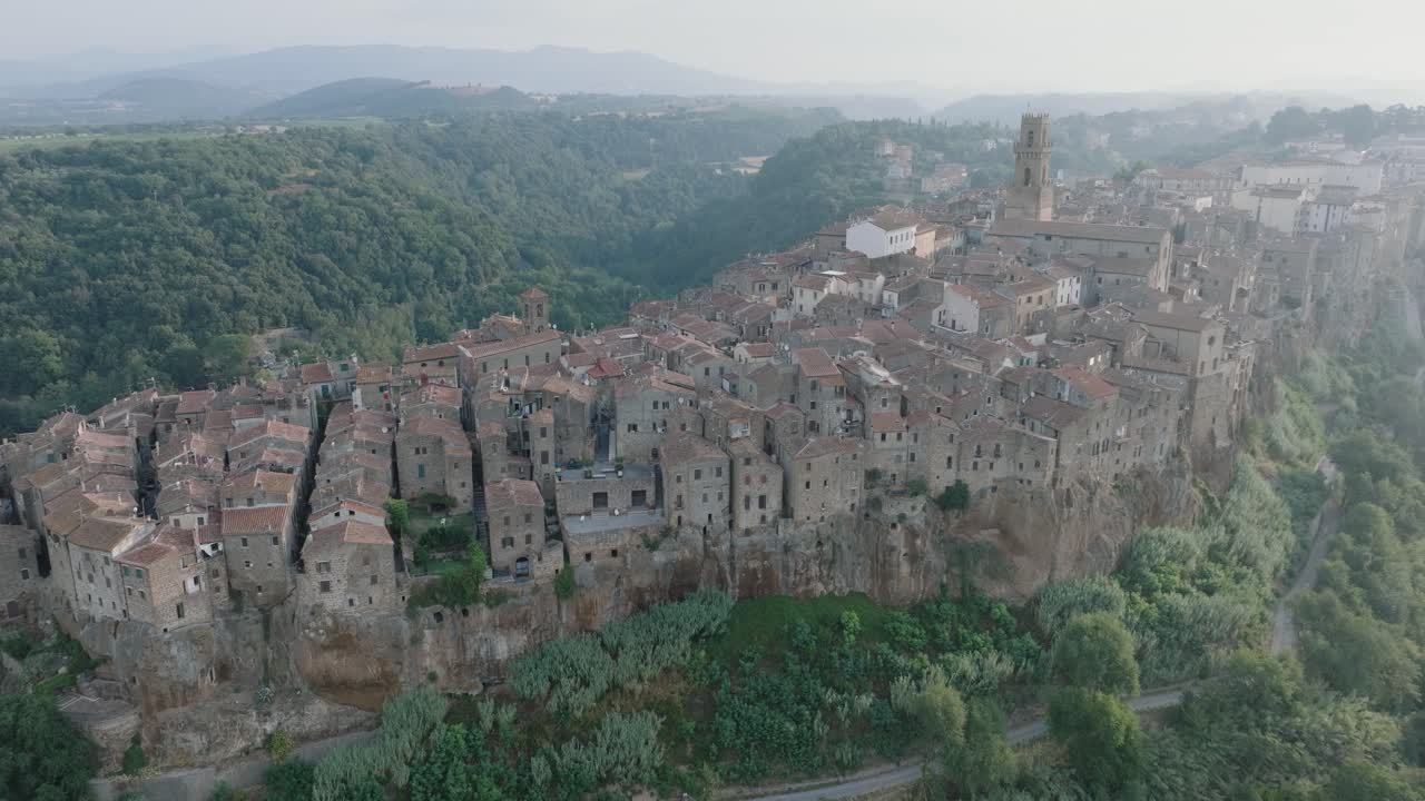 Drohnen-Luftaufnahme der mittelalterlichen Bergstadt Pitigliano, Toskana, im Morgenlicht, mit der Val d'Orcia und alten Gebäuden, in 4K.