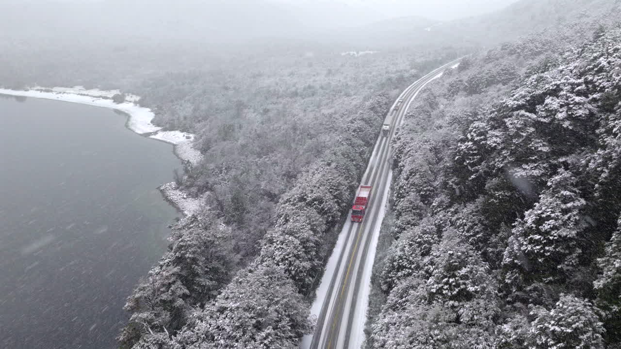 Scenic aerial view of a car driving along Route 40 covered in snow in Río Negro Patagonia Argentina, adventure road trip