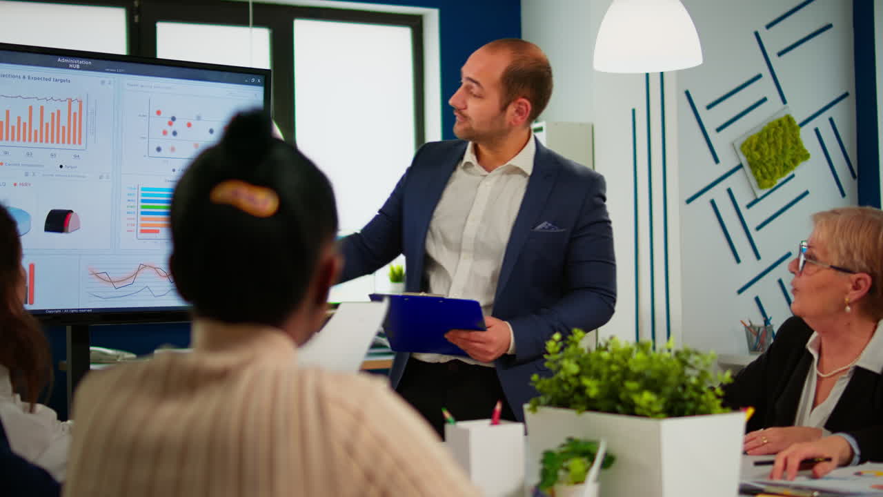 Business leader presenting company strategy to diverse team using digital whiteboard
