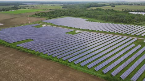 Green-Field-With-Rows-Of-Solar-Energy-Panels---aerial-drone-shot