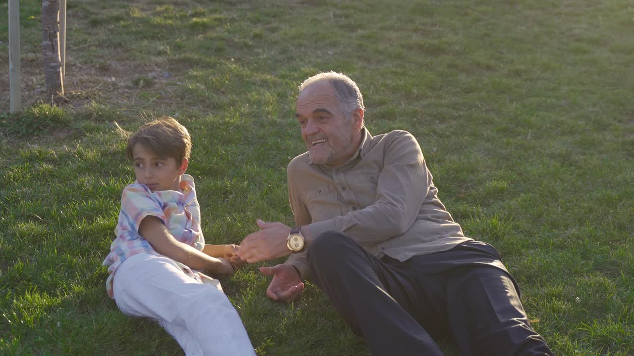 The old man and his grandson lying on the grass.