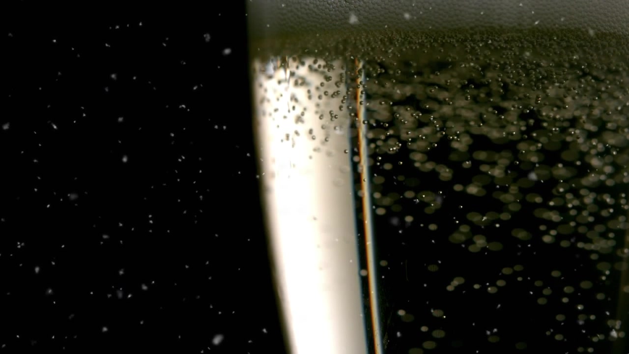 Animazione di neve che cade su un bicchiere di champagne