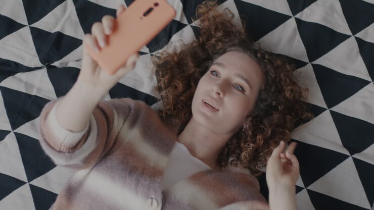Woman Taking a Selfie in Bed