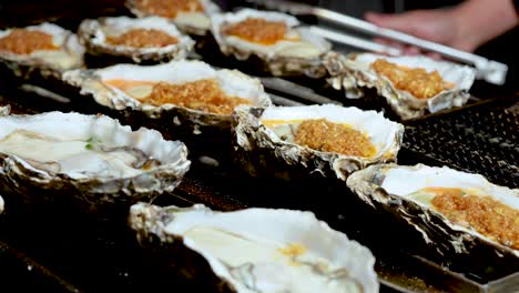 oysters being grilled with toppings in hong kong