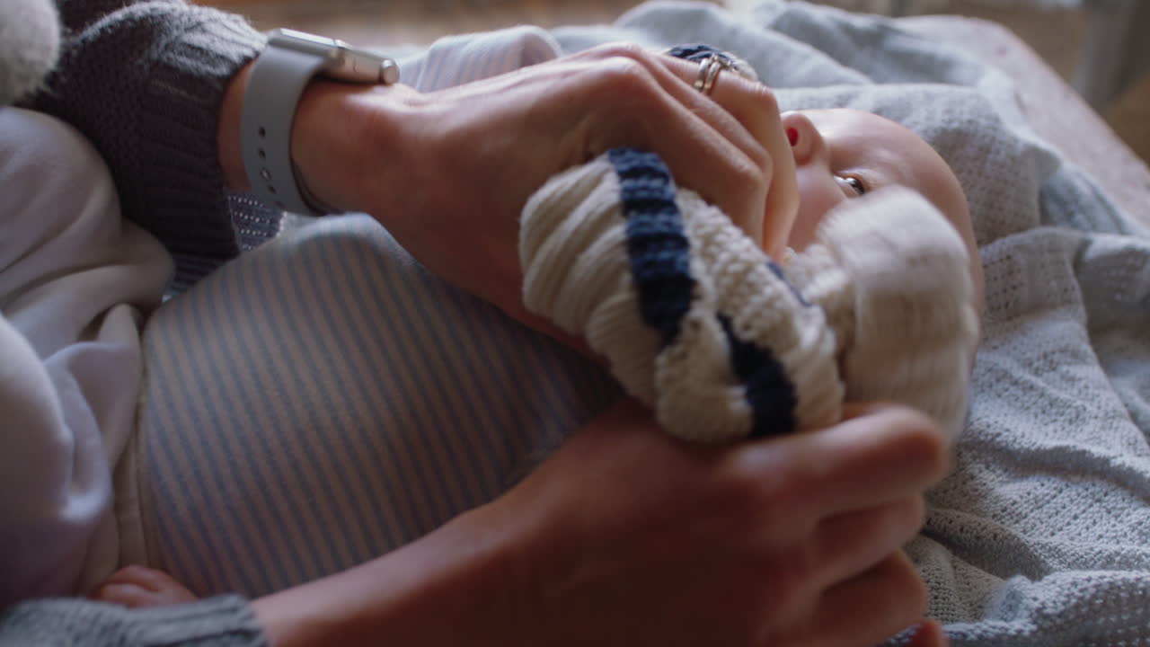 아기와 함께 행복한 어머니 아름다운 유아를 입히고 유아를 돌보는 부드러운 엄마 가정에서 아이를 키우는 어머니를 즐기고