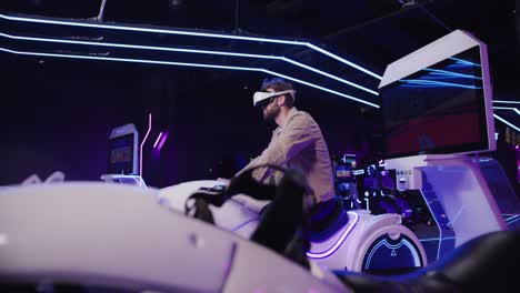 person wearing vr headset playing a motorcycle simulator game in an arcade