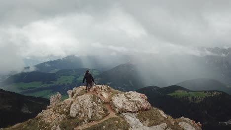 drone shot passing by a running adventurer on top of a mountain to reveal germany's beautiful countryside