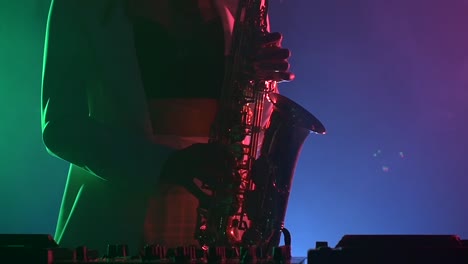 woman playing saxophone on stage with neon lights