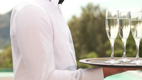 smiling waiter holding champagne glasses