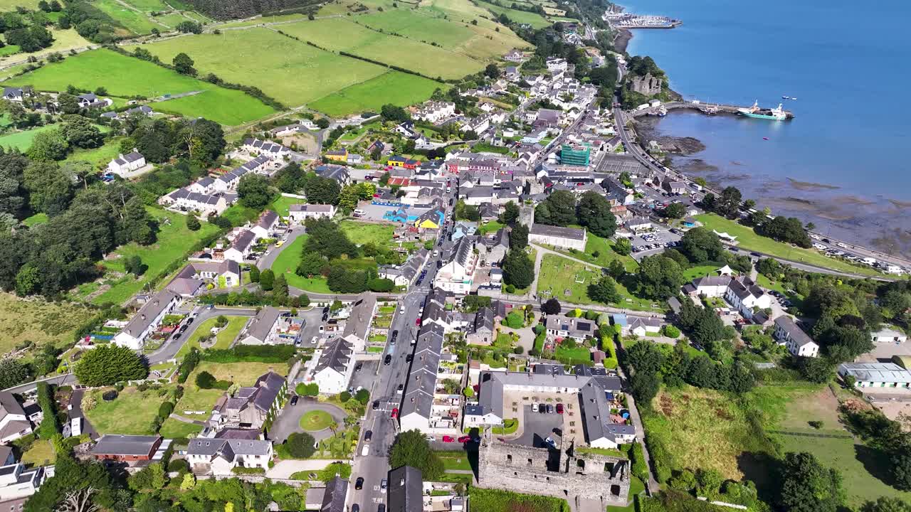 Wide aerial of Carlingford town on coast and bay during sunny morning in Ireland