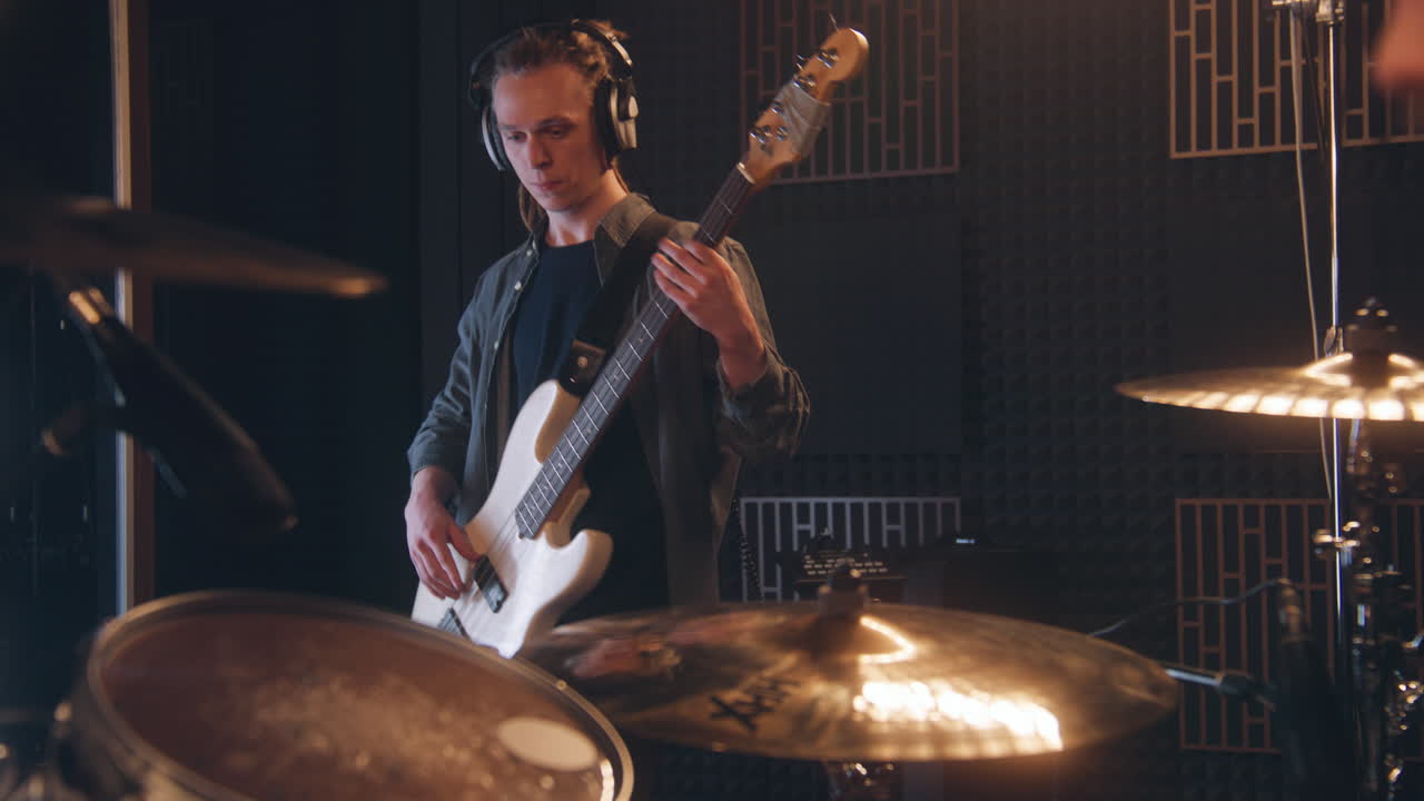 Musician playing bass guitar in recording studio