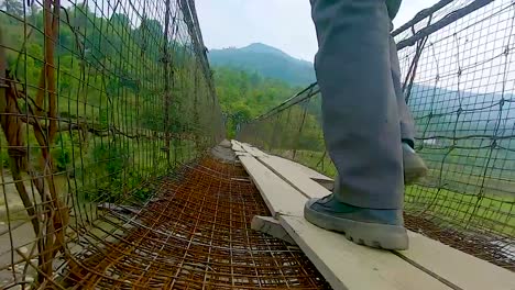 Ein-Mann,-Der-An-Einer-Vintage-Eisenhängebrücke-Aus-Einem-Niedrigen-Winkelvideo-Spazieren-Geht,-Wird-In-Nongjrong-Meghalaya,-Indien,-Aufgenommen