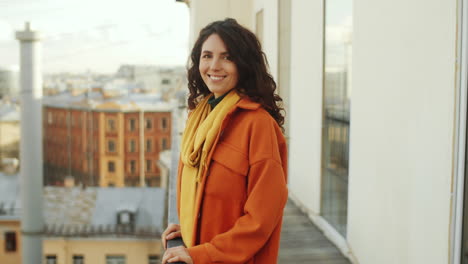 mujer alegre posando para la cámara en la terraza de la azotea