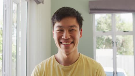 portrait of happy asian man smiling in living room