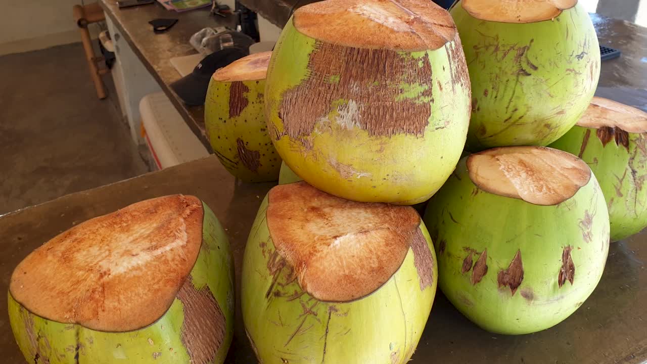 A stack of freshly cut healthy drinking coconuts at a bar cafe on remote tropical island in Southeast Asia. Refreshing and rehydrating.