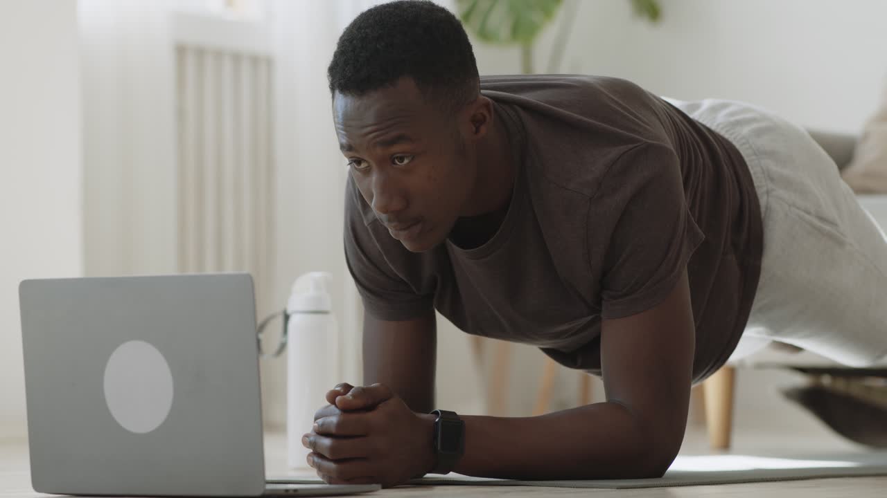 hombre haciendo ejercicio de tabla en casa