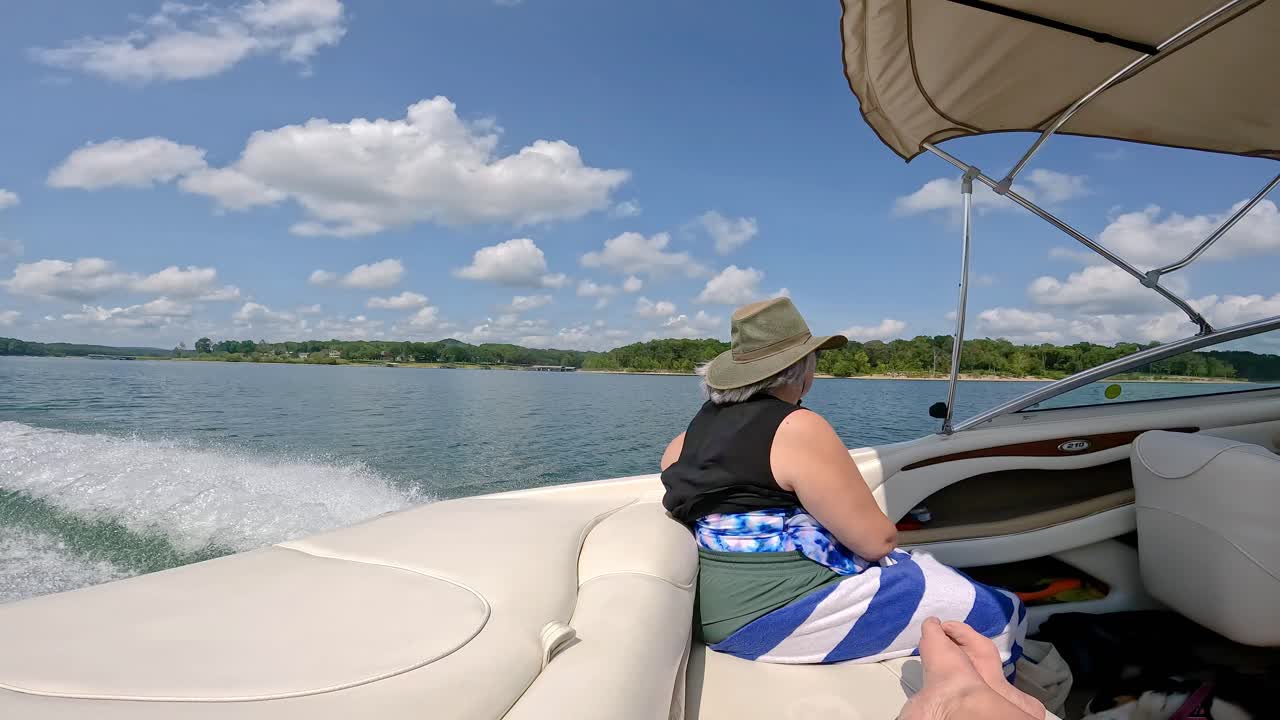 Table Rock Lake in Missouri USA - Woman sitting in back of sports boat cruising the lake on a sunny afternoon