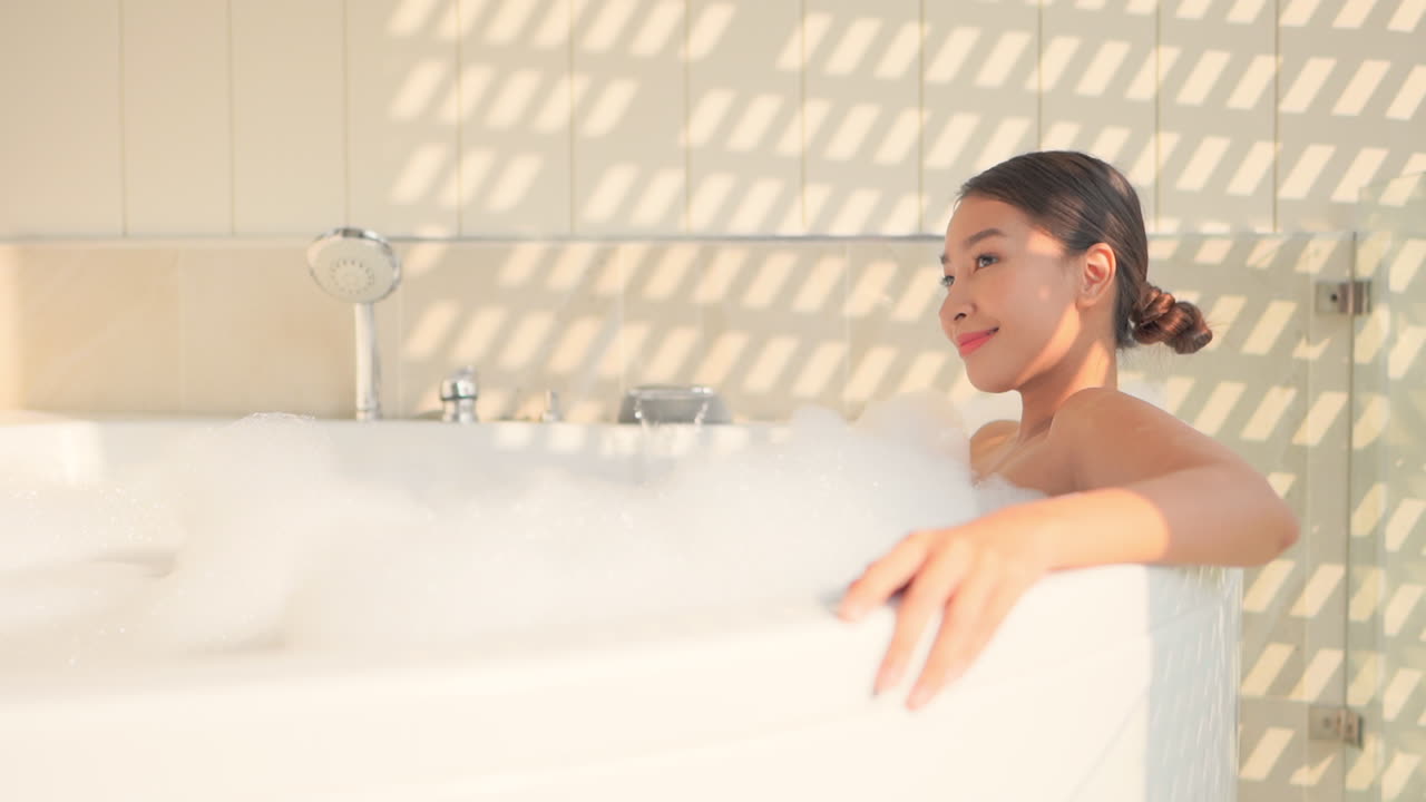 Woman relaxing in a bathtub with foam