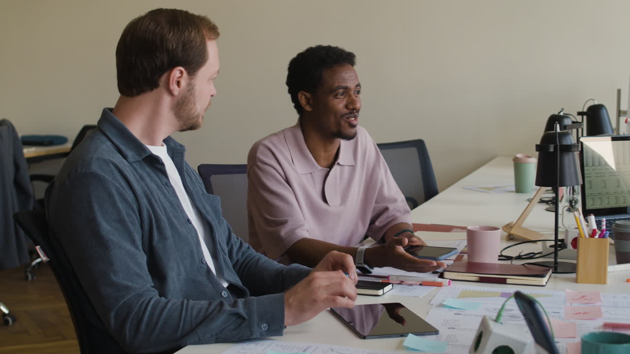 Coworkers Collaborating at a Desk in an Office Setting