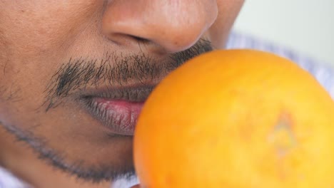 man smelling an orange