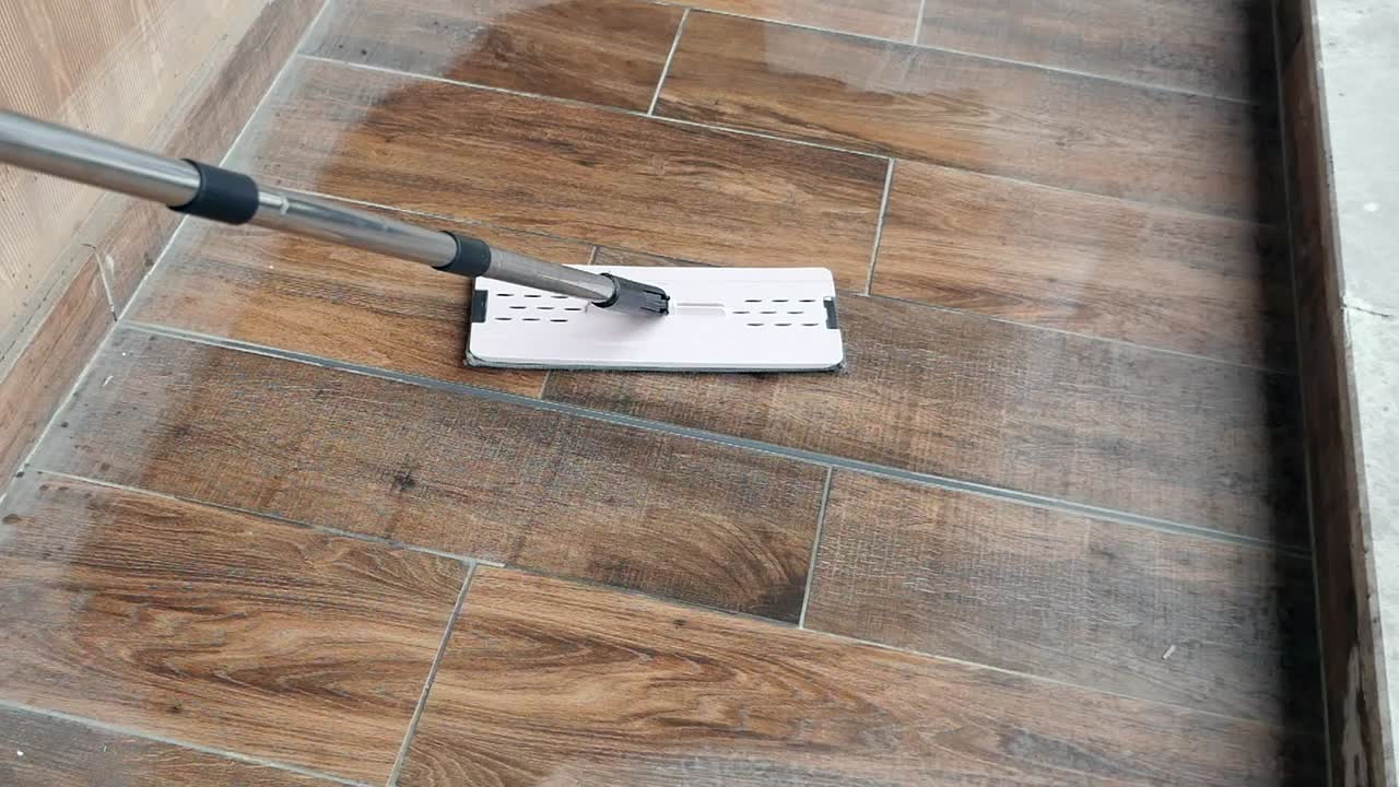 Cleaning a wet tiled floor with a mop