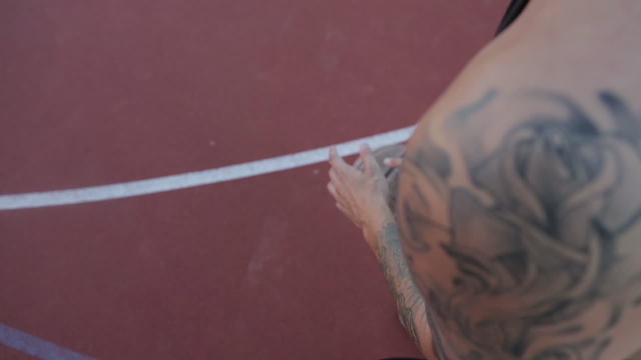 jugador de baloncesto en una cancha con un tatuaje