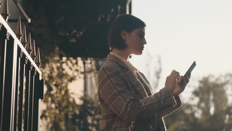 stylish woman using smartphone outdoor.