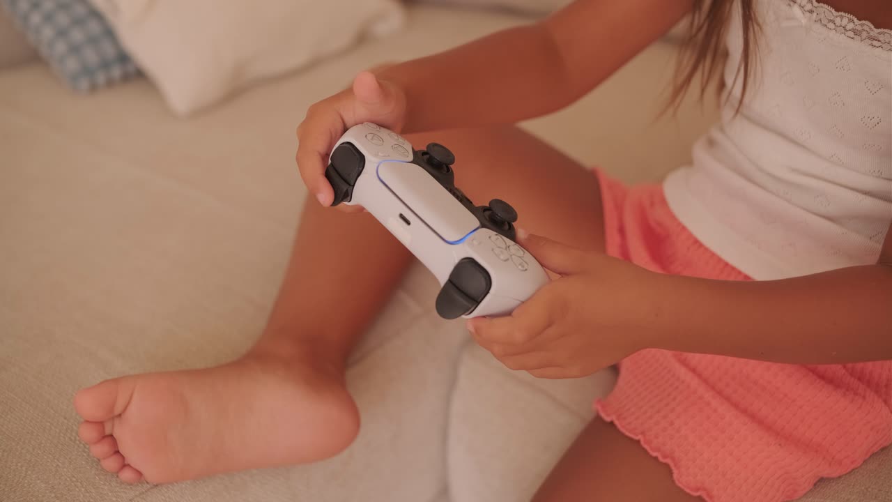 Child playing with a PS5 controller