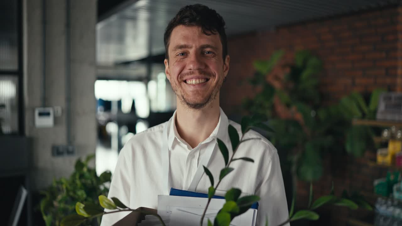 Man with a Box and Plant in an Office