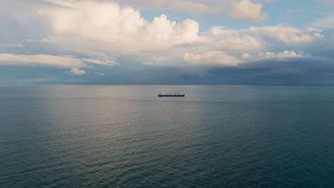 bulk carrier ship sailing at cloudy day. aerial view vessel floating dark ocean