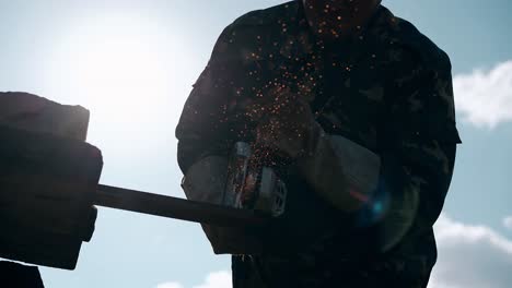 low-angle-shot-worker-silhouette-with-saw-against-sunlight