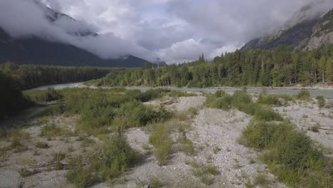 low cloudy aerial flight over gravel bar in flowing bella coola river