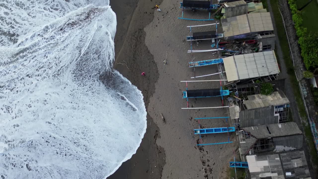 Bali Fishernan Village with a boat and a wave dirty beach with trash and sea at left side