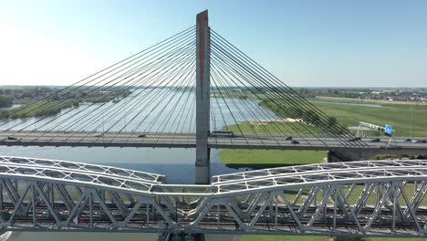 boat passing under railway bridge and highway bridge on a bright sunny day