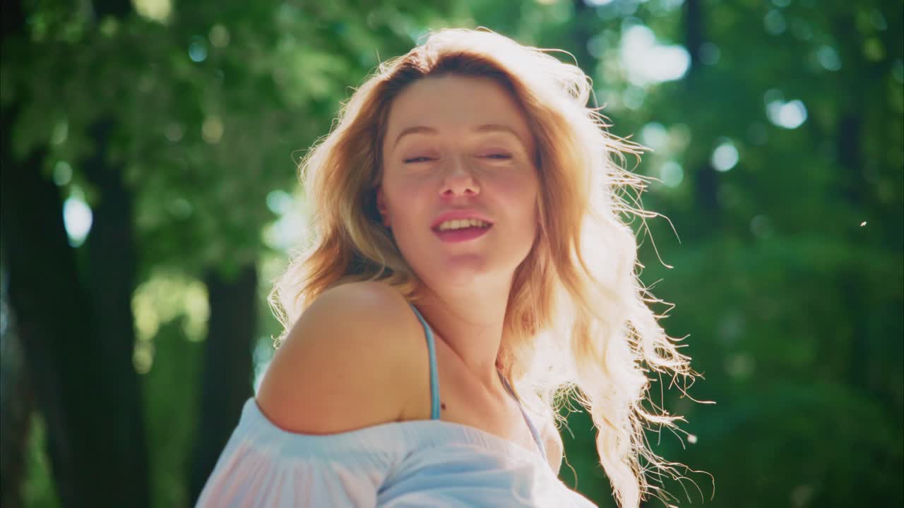 Donna bionda serena con capelli fluenti alla luce del sole