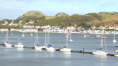 Various-fishing-boats-and-yachts-moored-along-scenic-hillside-tourism-town-waterfront-landscape