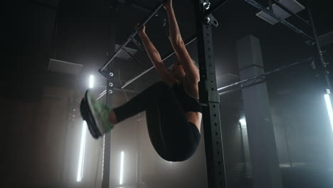 Escalada-Con-Cuerda-Durante-El-Entrenamiento-En-El-Gimnasio-Una-Mujer-Joven-Está-Trabajando-En-El-Travesaño-Levantando-Las-Piernas