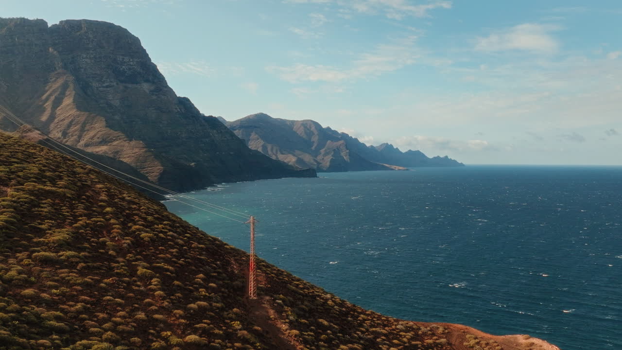 Scenic drone shot of sunlight falling on mountains and hills withblue ocean in front in Gran Canaria, Spain. Hilltop.