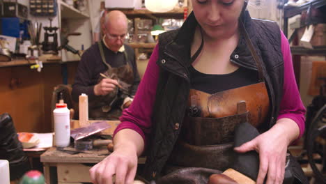 bespoke shoemaker pinning leather together to make shoe