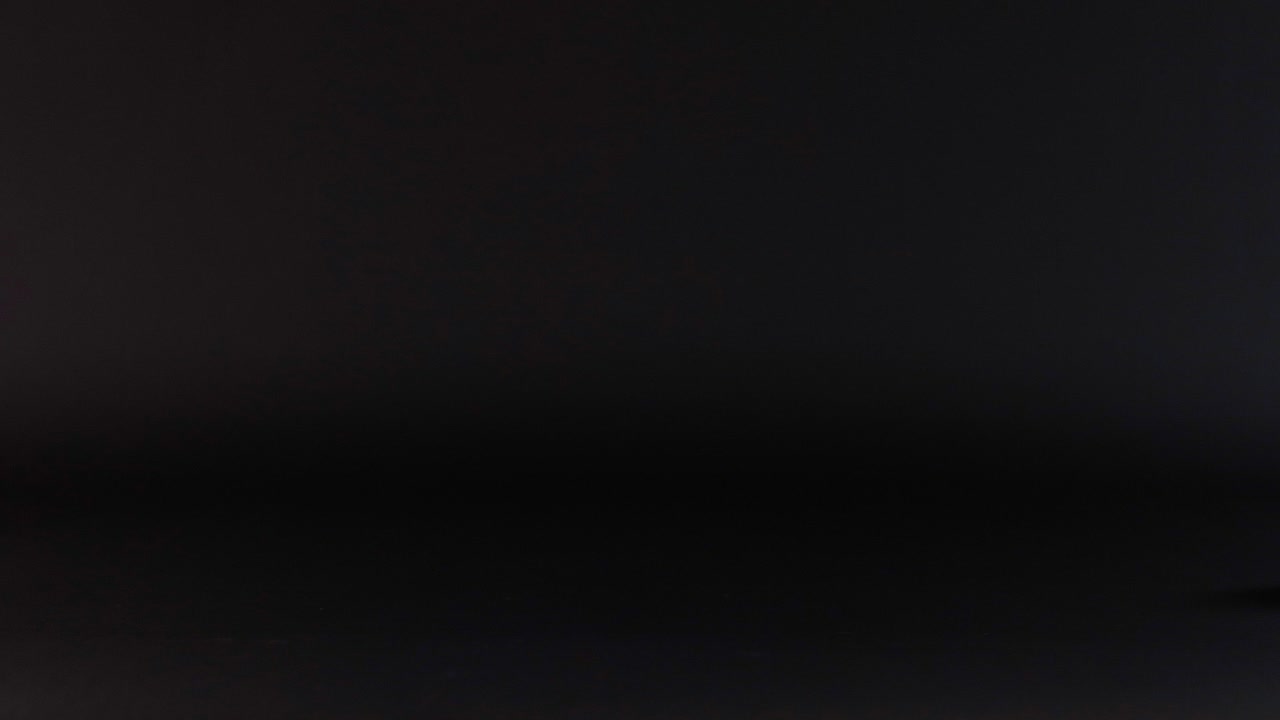 una pelota rosa rodando a través de una superficie oscura